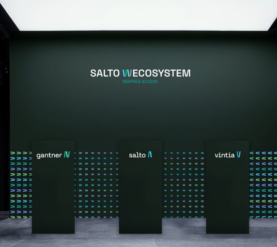 Auf moosgrünem Hintergrund stehen drei Säulen mit der Aufschrift "Salto W-Ecosystems". Die erste trägt das Logo von Gantner, die zweite das von Salto und die dritte das von Vintia. 